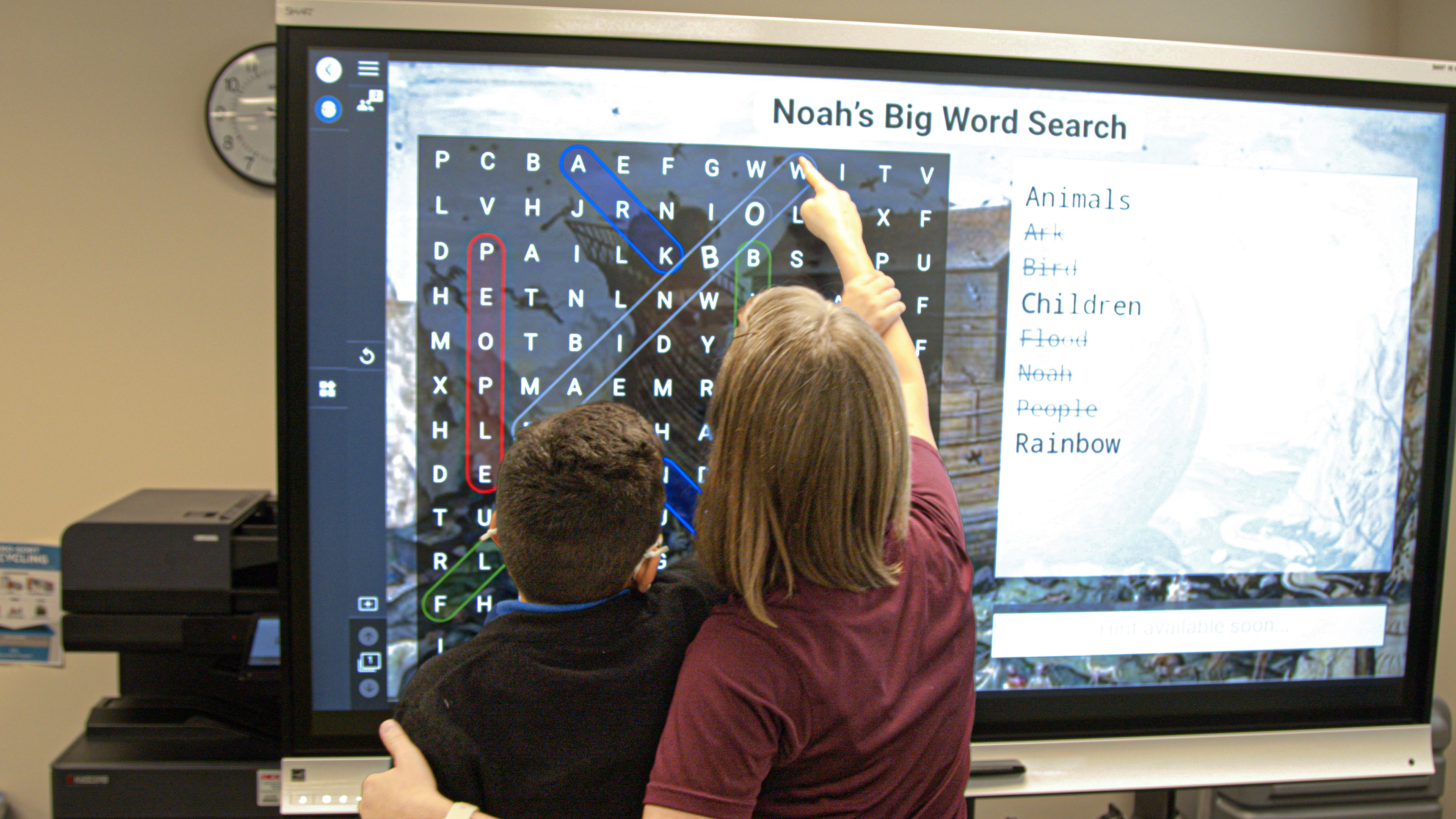 tearcher helping a student interact at a interactive school display